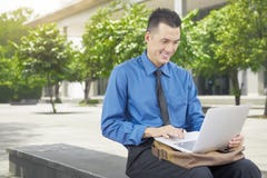 Smiling asian businessman using laptop Stock Photography Smiling asian businessman using laptop Stock Photography