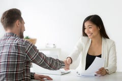 Smiling asian businesswoman handshaking businessman hiring or si