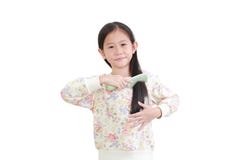 Smiling Asian Little Kid Girl Combing Long Hair On White. Hair Care Concept Royalty Free Stock Image