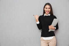 https://thumbs.dreamstime.com/t/smiling-asian-woman-business-clothes-holding-laptop-computer-pointing-copyspace-looking-camera-over-gray-108146467.jpg