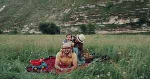 Smiling beautiful family at the picnic playing , in the middle of mountain stock footage Smiling beautiful family at the picnic playing , in the middle of mountain stock footage