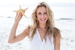 Smiling blonde in white dress holding starfish Royalty Free Stock Image Smiling blonde in white dress holding starfish Royalty Free Stock Image