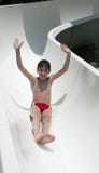 Smiling Boy Slides A Waterslide Royalty Free Stock Images
