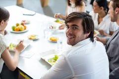 Smiling business executive having meal in office stock image Smiling business executive having meal in office stock image