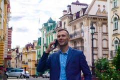 Smiling businessman using phone in city. stock photos Smiling businessman using phone in city. stock photos
