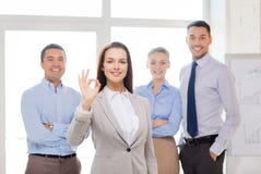 Smiling businesswoman showing ok-sign in office Royalty Free Stock Image Smiling businesswoman showing ok-sign in office Royalty Free Stock Image