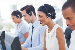 Smiling call center employees sitting in line