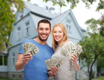 Smiling couple showing money over house background royalty free stock image Smiling couple showing money over house background royalty free stock image