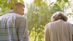Smiling couple walking in summer forest holding picnic basket back view, date stock video Smiling couple walking in summer forest holding picnic basket back view, date stock video