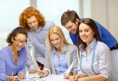 Smiling creative team looking over clothes designs Royalty Free Stock Images Smiling creative team looking over clothes designs Royalty Free Stock Images