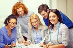 Smiling creative team looking over clothes designs Royalty Free Stock Image Smiling creative team looking over clothes designs Royalty Free Stock Image