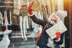 Smiling curly blond girl with map making selfie, winter stock images Smiling curly blond girl with map making selfie, winter stock images