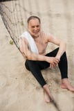 smiling elderly man with towel resting near net on sandy beach after stock photography smiling elderly man with towel resting near net on sandy beach after stock photography