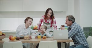 Smiling family in the morning while taking breakfast before work and school they have time to watching something stock footage Smiling family in the morning while taking breakfast before work and school they have time to watching something stock footage