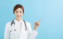 female doctor pointing with finger on blue background Royalty Free Stock Photo female doctor pointing with finger on blue background Royalty Free Stock Photo