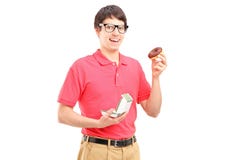A smiling guy wearing red t-shirt and eating a donut Stock Image A smiling guy wearing red t-shirt and eating a donut Stock Image