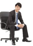Smiling and handsome Young business man sitting on a chair royalty free stock image Smiling and handsome Young business man sitting on a chair royalty free stock image
