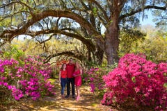 Smiling happy family enjoying time together in beautiful blooming garden on a spring day stock photo Smiling happy family enjoying time together in beautiful blooming garden on a spring day stock photo