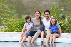 Smiling happy family by swimming pool stock photo Smiling happy family by swimming pool stock photo