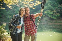 Smiling happy young couple hiking along the lake shore, embracing each other stock image Smiling happy young couple hiking along the lake shore, embracing each other stock image
