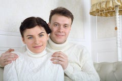 https://thumbs.dreamstime.com/t/smiling-husband-white-sweaters-hugs-wife-shoulders-sofa-home-34550781.jpg