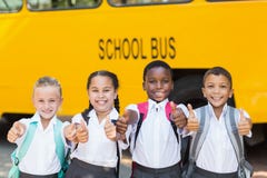 Smiling kids showing thumbs up in front of school bus Royalty Free Stock Image Smiling kids showing thumbs up in front of school bus Royalty Free Stock Image