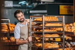 smiling male shop assistant arranging fresh pastry stock images smiling male shop assistant arranging fresh pastry stock images