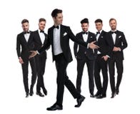 Smiling man in tuxedo walks and welcomes while looking back stock images Smiling man in tuxedo walks and welcomes while looking back stock images