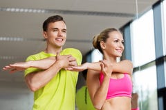 Smiling man and woman exercising in gym stock image Smiling man and woman exercising in gym stock image