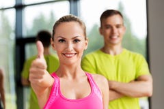 Smiling man and woman showing thumbs up in gym royalty free stock image Smiling man and woman showing thumbs up in gym royalty free stock image