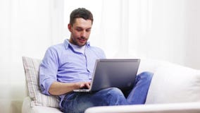 Smiling man working with laptop at home