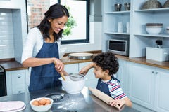 Smiling mother cooking with her son stock photo Smiling mother cooking with her son stock photo