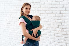 Smiling mother with newborn baby in baby sling. royalty free stock photos Smiling mother with newborn baby in baby sling. royalty free stock photos