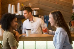 Multiracial girlfriends laughing, enjoying drinks at bar counter stock photo Multiracial girlfriends laughing, enjoying drinks at bar counter stock photo