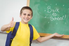 Smiling pupil showing back to school sign on chalkboard stock images Smiling pupil showing back to school sign on chalkboard stock images