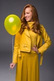 smiling redhead fashionable girl in yellow leather jacket with balloon stock photo smiling redhead fashionable girl in yellow leather jacket with balloon stock photo