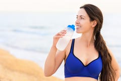 Woman drinks water on the sea beach stock images Woman drinks water on the sea beach stock images