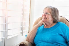 Smiling Senior Woman Gazing Out of Her Window Stock Images Smiling Senior Woman Gazing Out of Her Window Stock Images