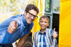Smiling teacher and schoolboy showing thumbs up in front of school bus royalty free stock image Smiling teacher and schoolboy showing thumbs up in front of school bus royalty free stock image