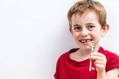 Smiling toothless boy showing a key for fun tooth fairy royalty free stock photography Smiling toothless boy showing a key for fun tooth fairy royalty free stock photography