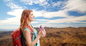 Smiling woman with backpack over mountains Royalty Free Stock Photography Smiling woman with backpack over mountains Royalty Free Stock Photography