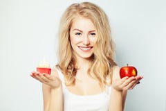 Smiling Woman with Healthy and Unhealthy Food stock photo Smiling Woman with Healthy and Unhealthy Food stock photo