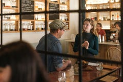 Smiling young waitress talking with a bistro customer stock images Smiling young waitress talking with a bistro customer stock images