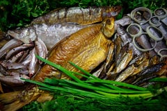 Smoked and salted river fish in the range served with vegetables Royalty Free Stock Photos Smoked and salted river fish in the range served with vegetables Royalty Free Stock Photos