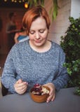 Smoothie Acai, granola, семена, свежие фрукты в деревянном шаре в женских руках на серой таблице Еда здорового шара завтрака стоковые изображения Smoothie Acai, granola, семена, свежие фрукты в деревянном шаре в женских руках на серой таблице Еда здорового шара завтрака стоковые изображения