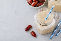 Smoothie ou milkshake de banane et de fruit de date dans le pot de maçon en verre Photos libres de droits Smoothie ou milkshake de banane et de fruit de date dans le pot de maçon en verre Photos libres de droits
