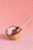 Smoothie rose avec la banane dans la cuvette de coquille de noix de coco sur le fond rose photo stock Smoothie rose avec la banane dans la cuvette de coquille de noix de coco sur le fond rose photo stock