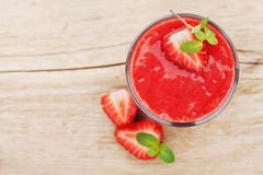 Smoothie клубники в стекле украшенном с листьями мяты на деревенской предпосылке, соке свежих фруктов, еде вытрезвителя, взгляд с Стоковые Фото Smoothie клубники в стекле украшенном с листьями мяты на деревенской предпосылке, соке свежих фруктов, еде вытрезвителя, взгляд с Стоковые Фото