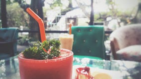 Smoothie клубники конца-вверх на предпосылке зеленая софа стоковое изображение rf Smoothie клубники конца-вверх на предпосылке зеленая софа стоковое изображение rf