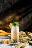 Smoothies délicieux d'une banane dans un beau verre décoré de la menthe sur un fond en bois images libres de droits Smoothies délicieux d'une banane dans un beau verre décoré de la menthe sur un fond en bois images libres de droits